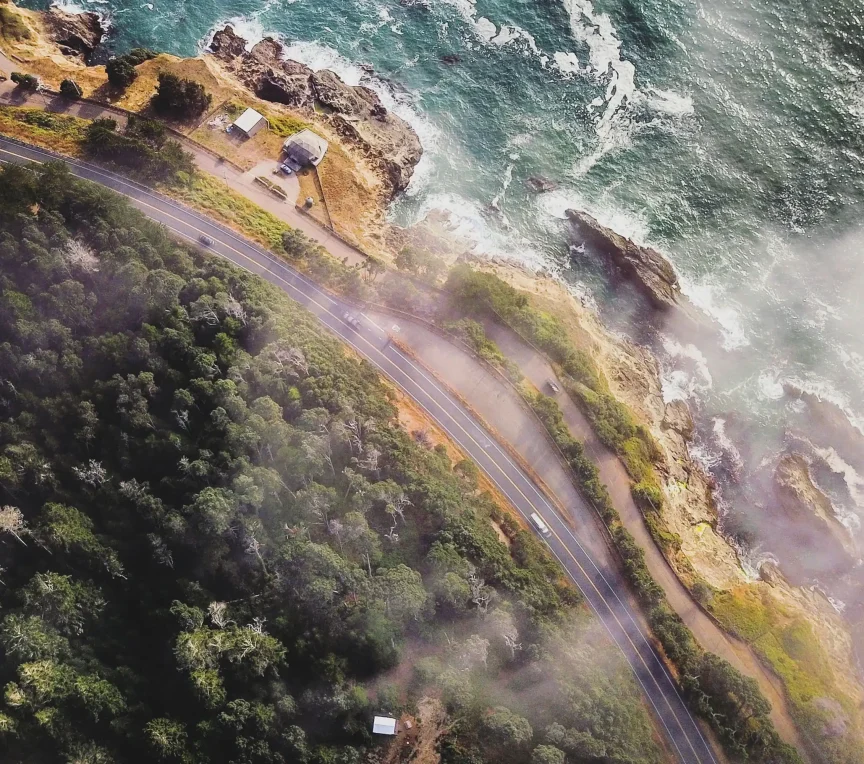 Aerial view of Mendocino coastline with rugged cliffs and crashing waves