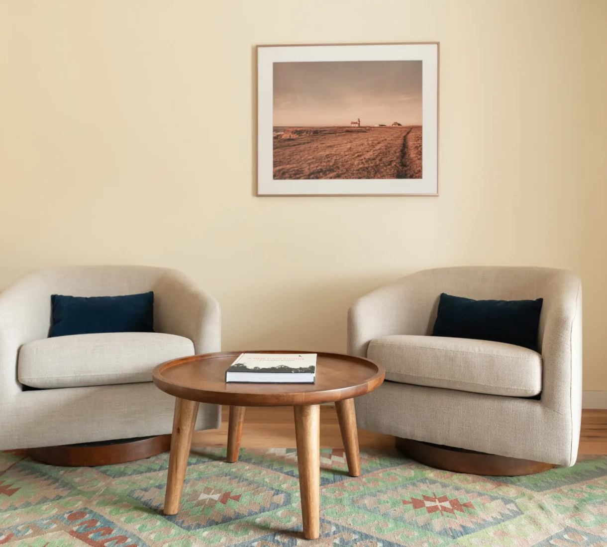 Coastal style hotel seating area in Mendocino resort with armchairs, rug, and wall art