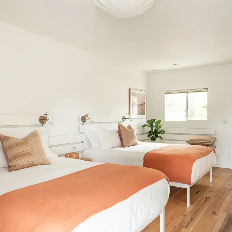 Fort Bragg hotel with two queen beds, wood floors, and modern wall lighting