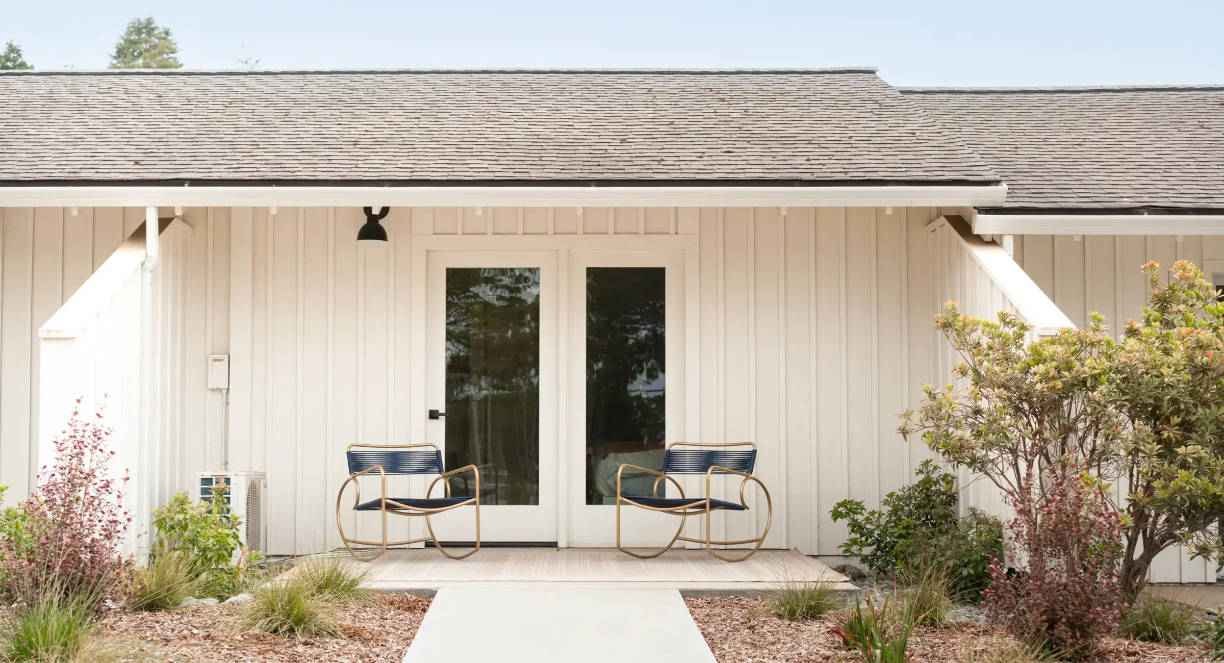 Exterior of Mendocino, CA hotel room with private patio and two blue chairs