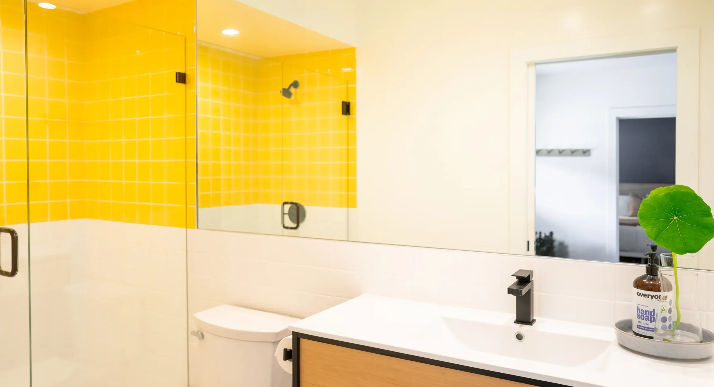Modern Mendocino Coast suite bathroom with glass shower and yellow tile design