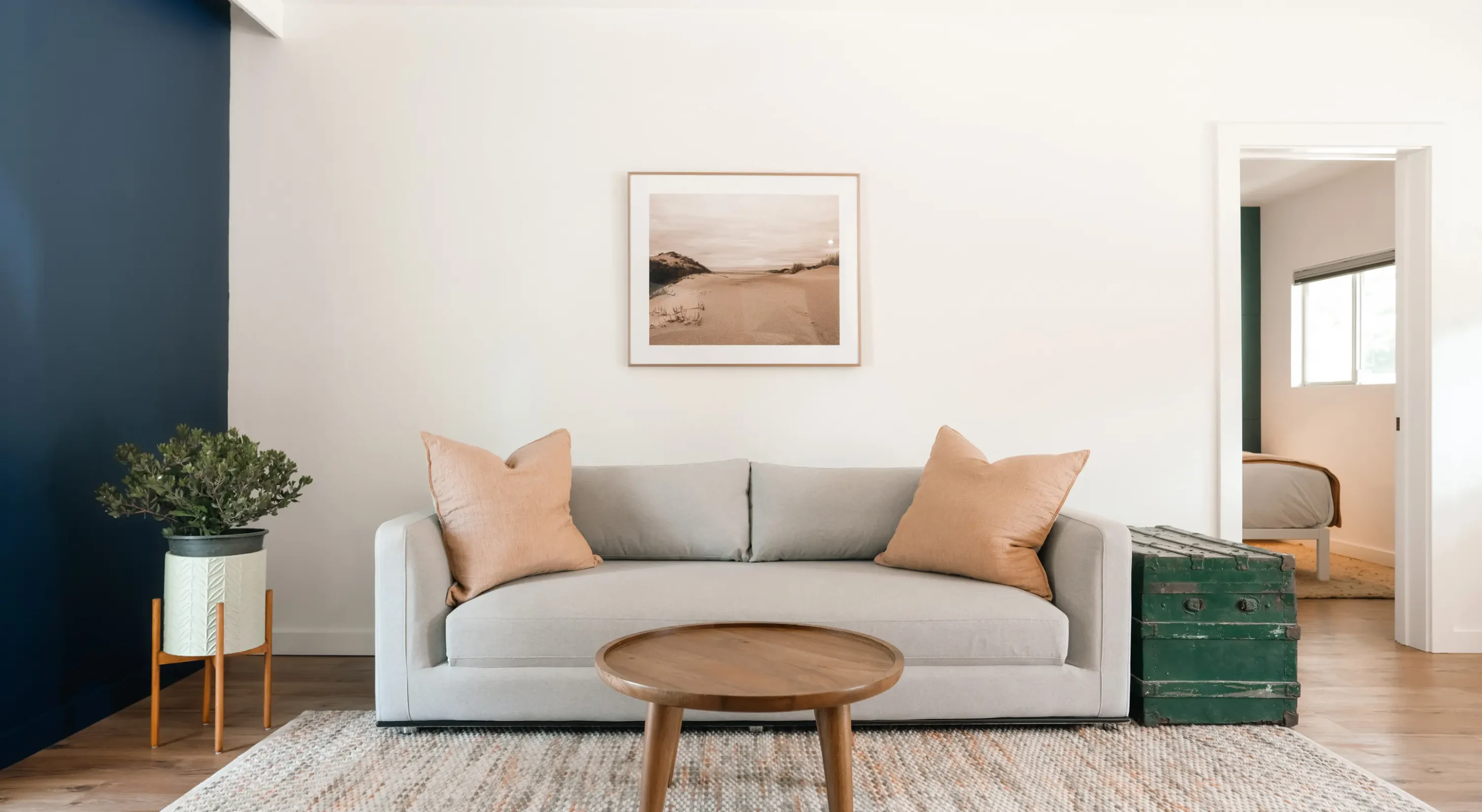 Mendocino boutique hotel suite living room with gray sofa, accent chairs, and coastal artwork