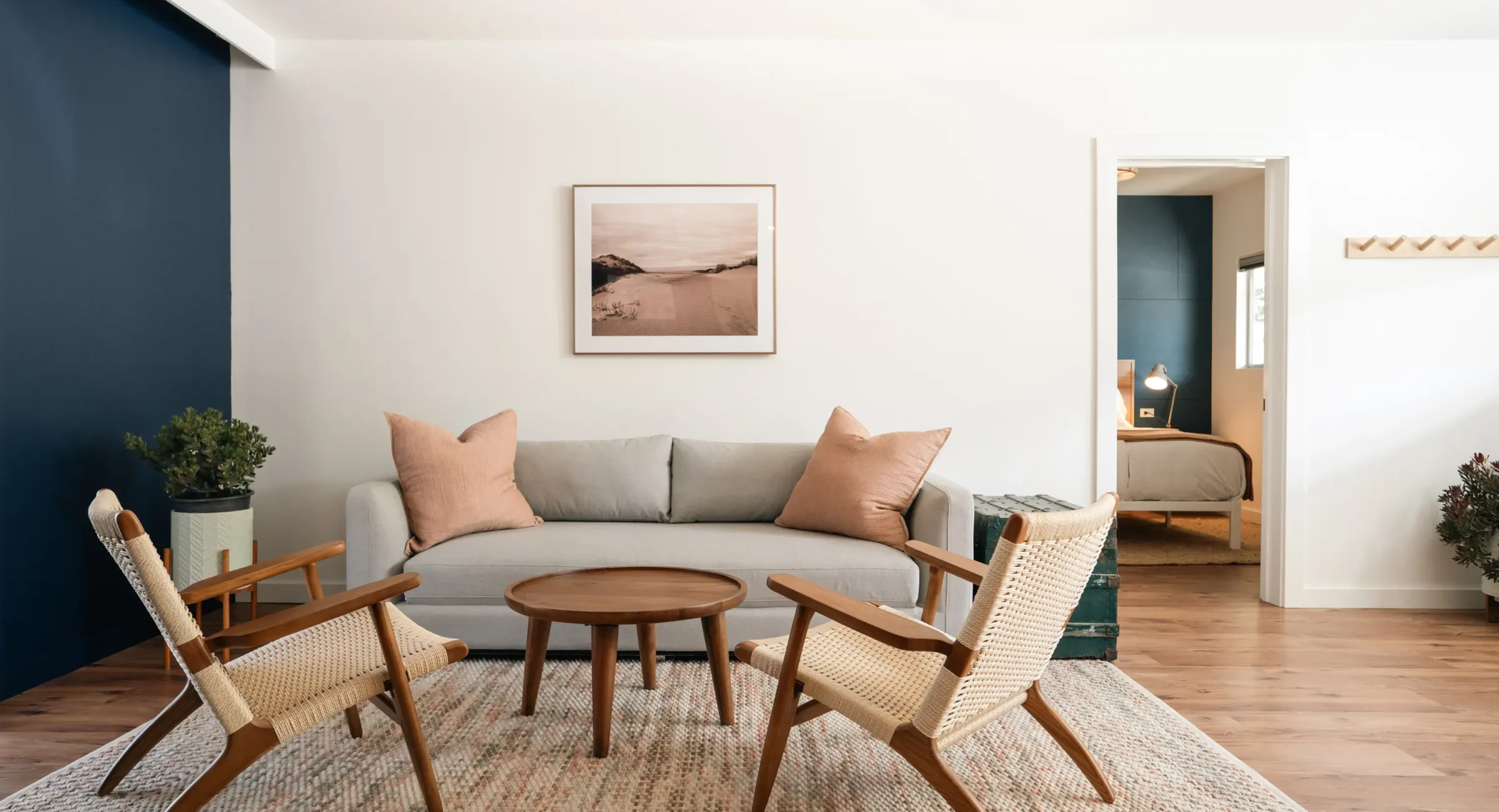 Mendocino boutique hotel suite living room with gray sofa, accent chairs, and coastal artwork