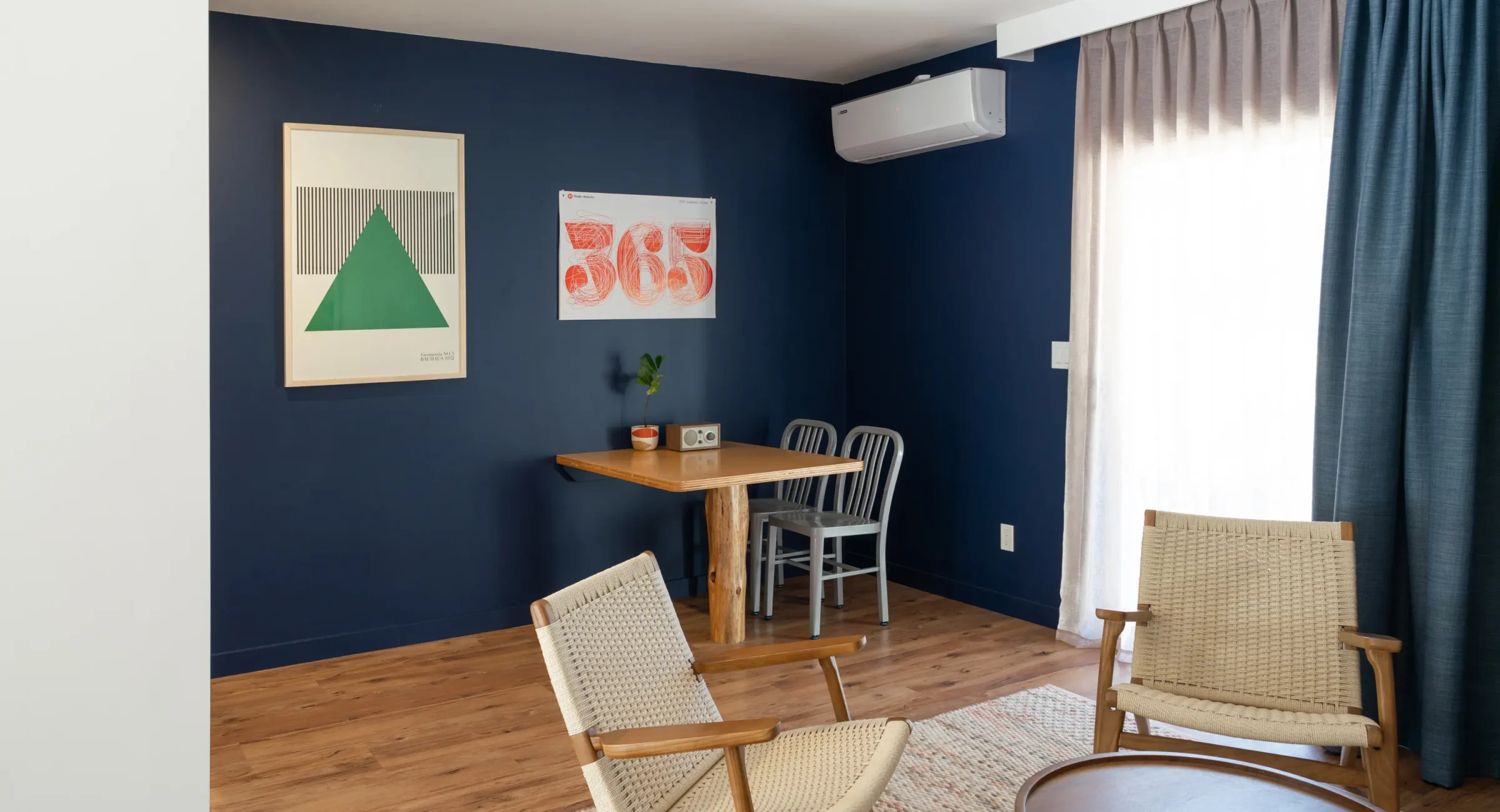 Mendocino boutique suite sitting area with navy accent wall and dining table for two