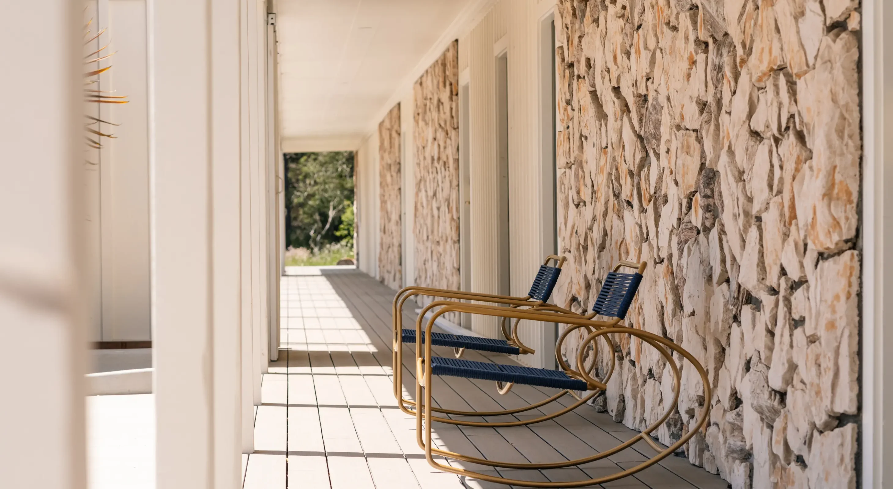 Covered walkway with rocking chairs outside guestrooms in Fort Bragg lodging