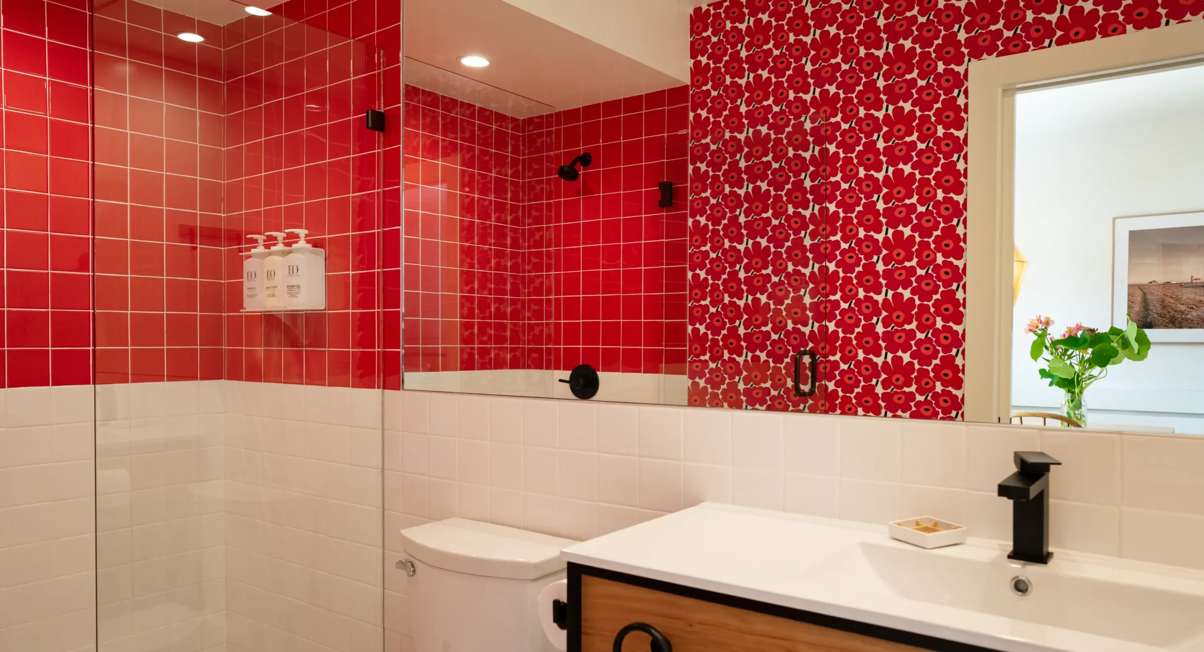 Modern Mendocino resort bathroom with walk-in shower, red floral tile, and vanity sink