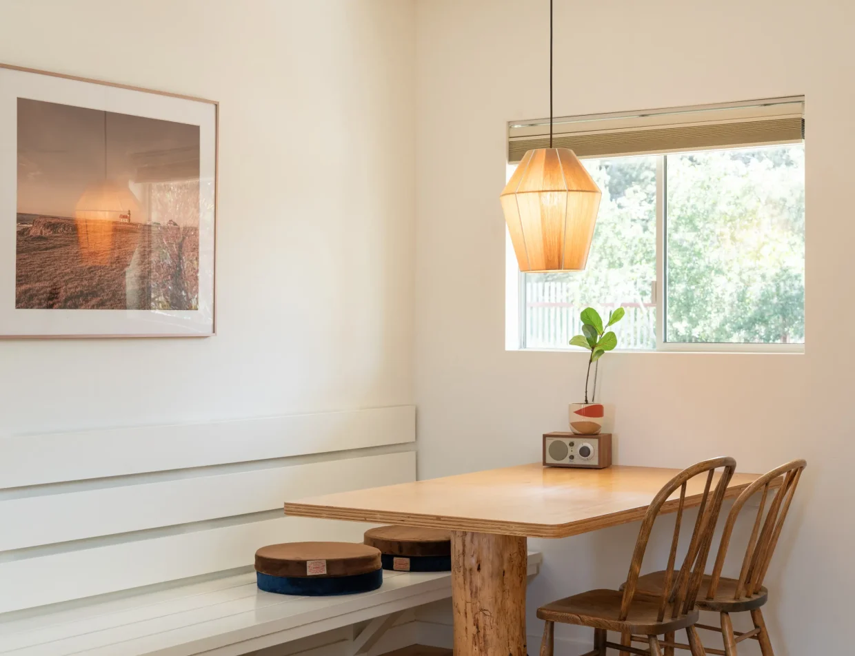 Dining area in Mendocino hotel king room with wood table, pendant light, and framed art