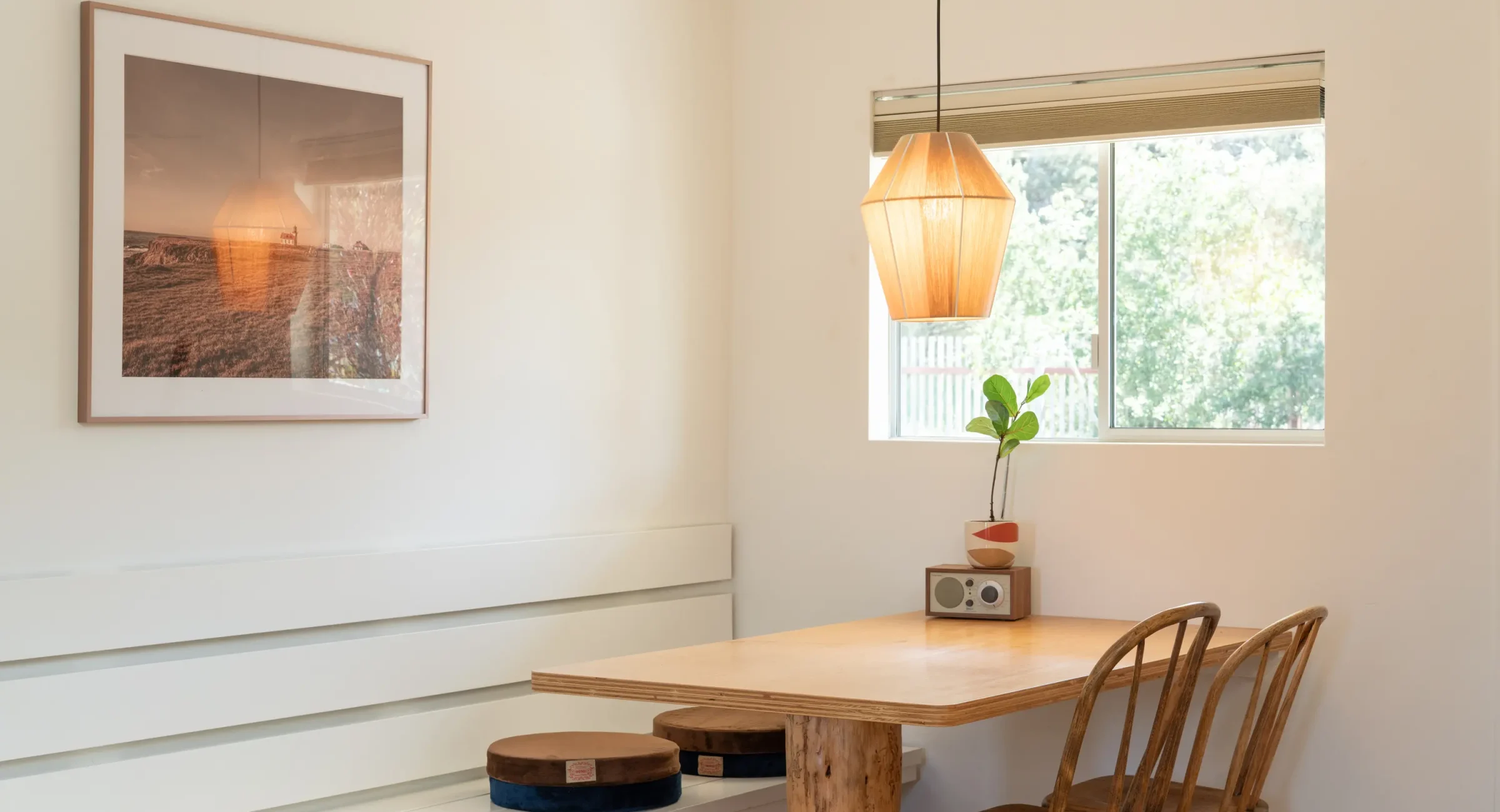 Dining area in Mendocino hotel king room with wood table, pendant light, and framed art