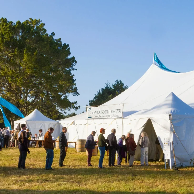 Community gathering under white festival tent on Mendocino Coast for the Mendocino Film Festival